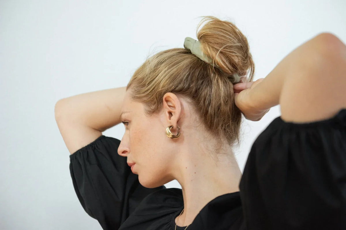 Hair being gathered by hand in soft light